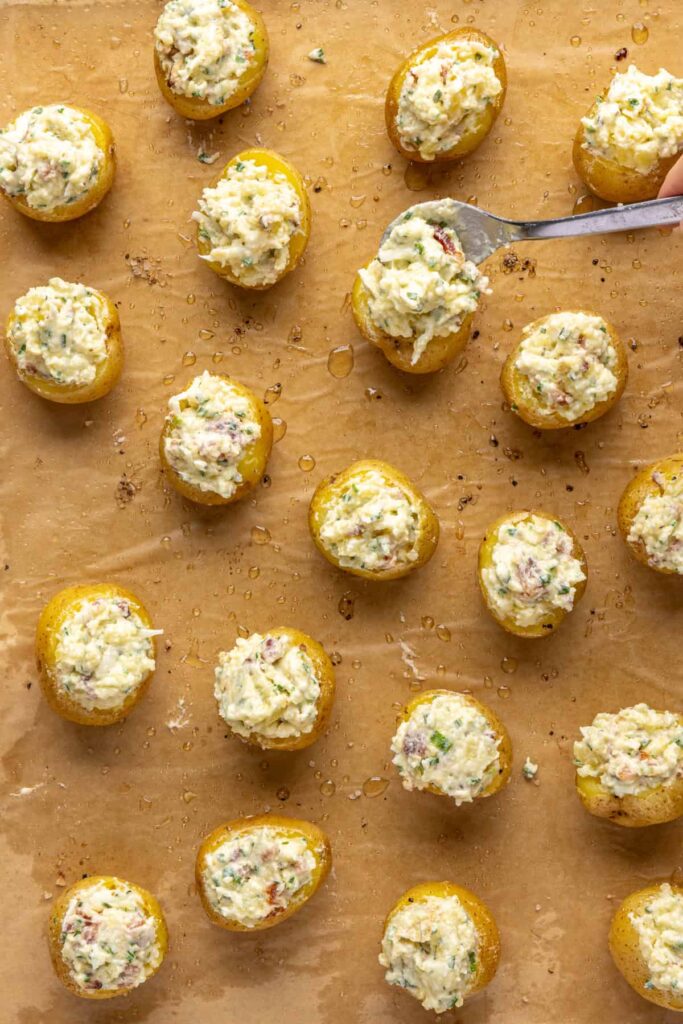 Filling being spooned into baked potato shells