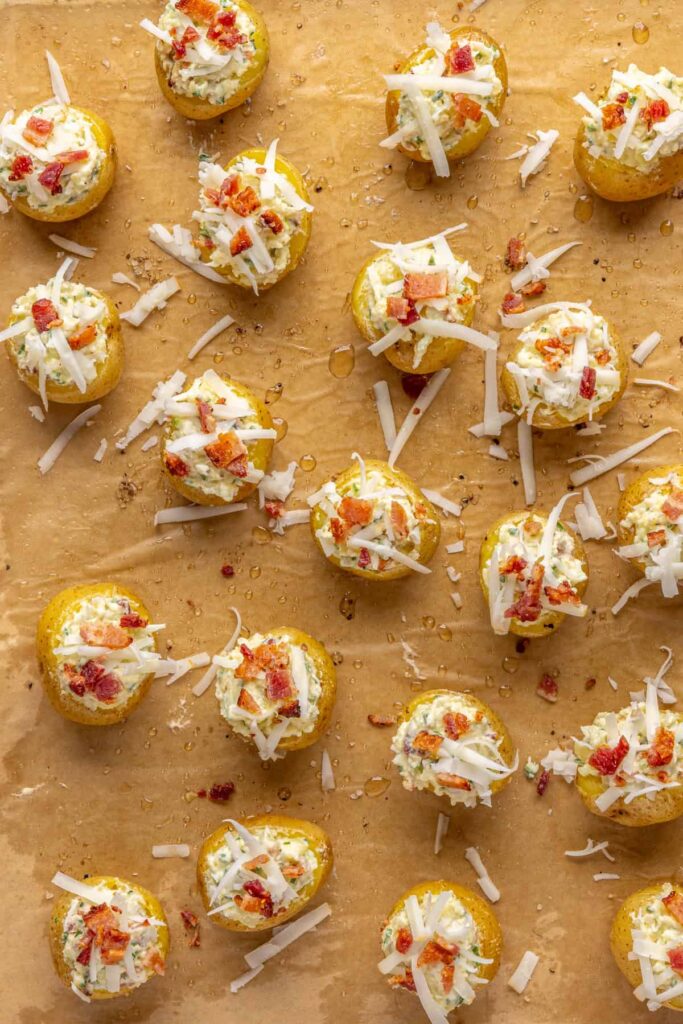 Twice baked potatoes topped with cheese and bacon before final bake