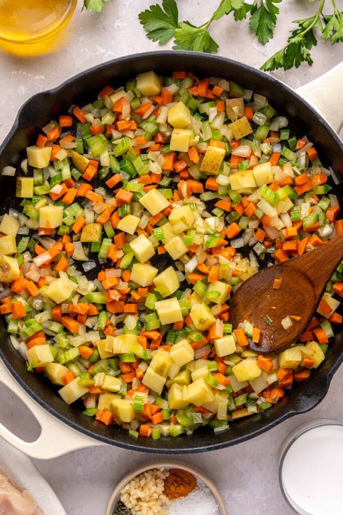 Vegetables in skillet seasoned with thyme, sage, garlic, and spices for chicken pot pie base