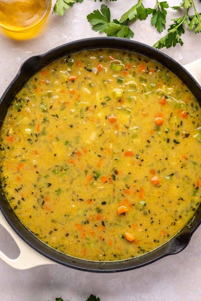 creamy vegetable mixture in a skillet waiting for chicken to be returned for one pot chicken pot pie