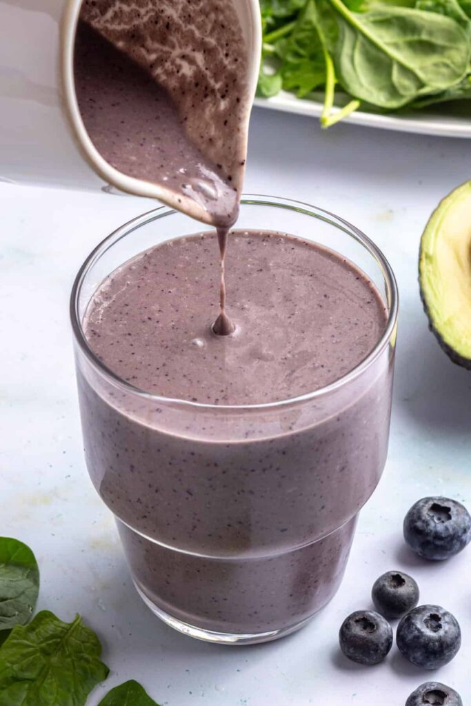 Pouring freshly blended toddler smoothie into a glass