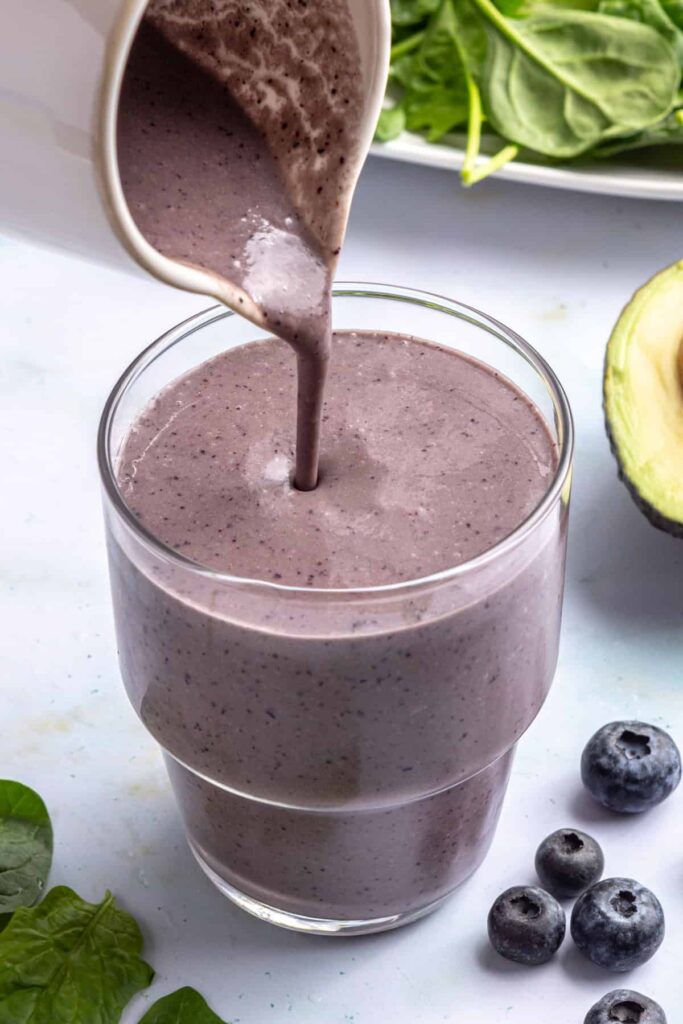 Pouring freshly blended toddler smoothie into a glass