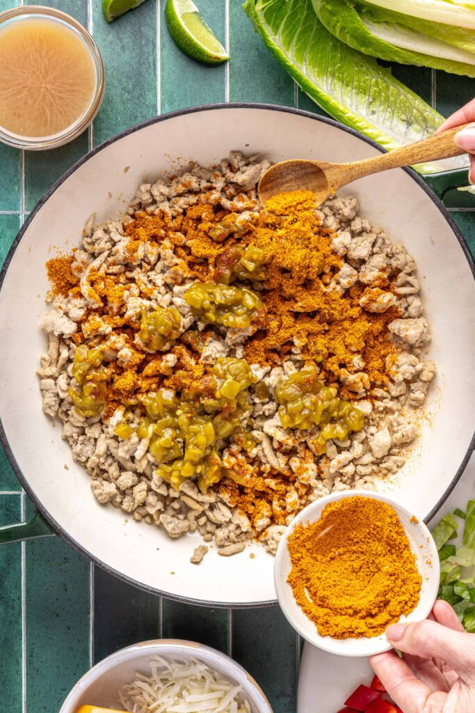 Taco seasoning and canned green chiles added to browned ground turkey while making turkey tacos