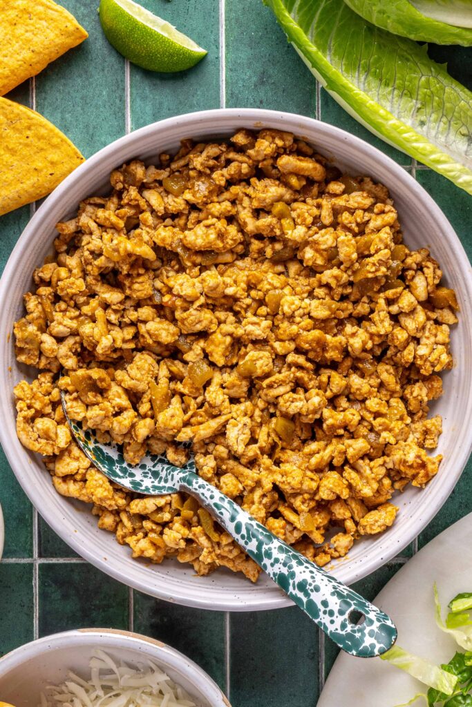 Finished ground turkey taco filling served in a bowl with spoon