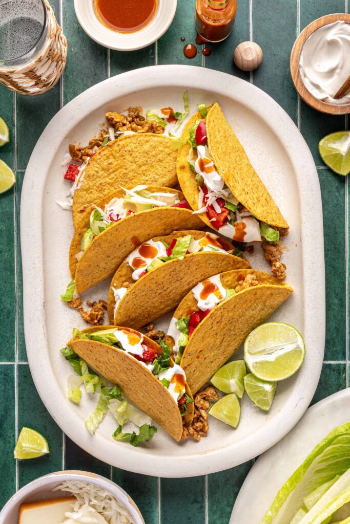 Easy turkey tacos assembled with seasoned ground turkey, fresh veggies, dairy-free sour cream, hot sauce, and crunchy shells
