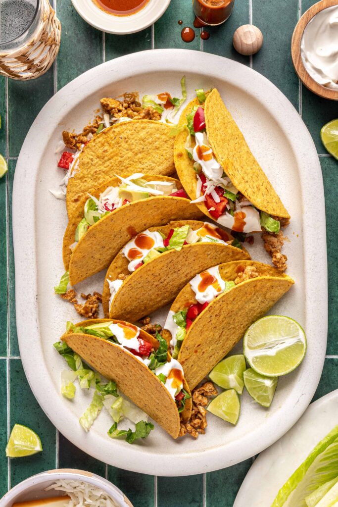 Turkey tacos served on a platter with lime wedges and fresh toppings