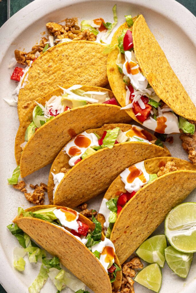 Turkey tacos served on a platter with lime wedges and fresh toppings
