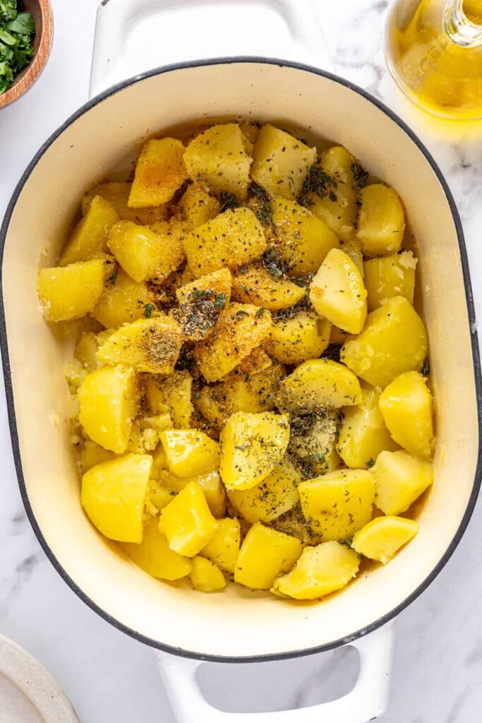 Seasoned potatoes coated in olive oil and herbs for English roast potatoes