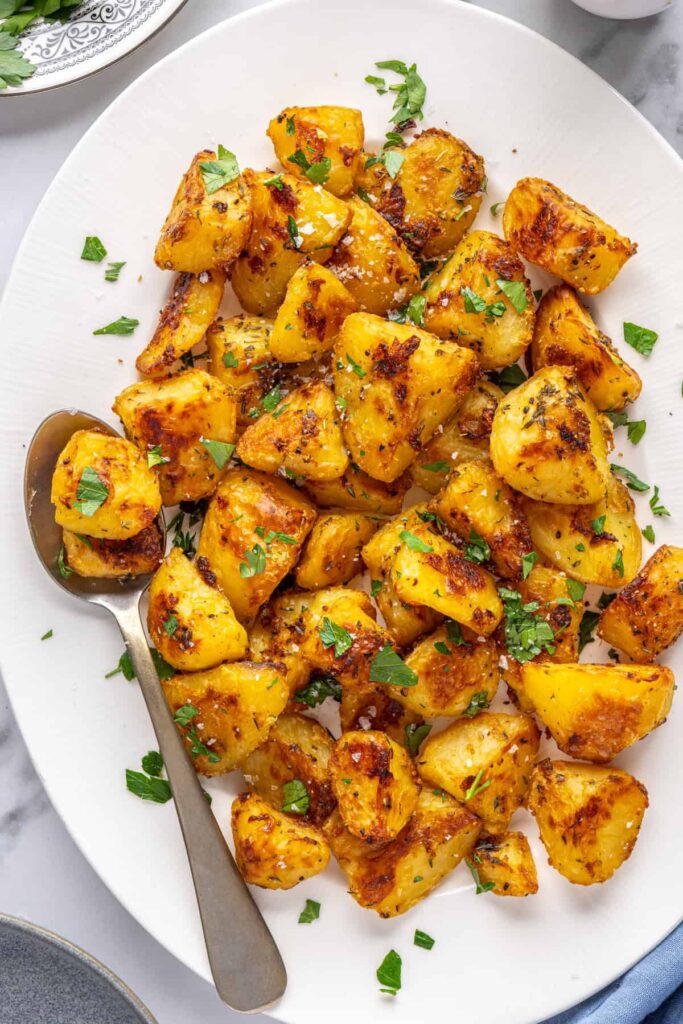 Herbed English roast potatoes served family-style on a platter
