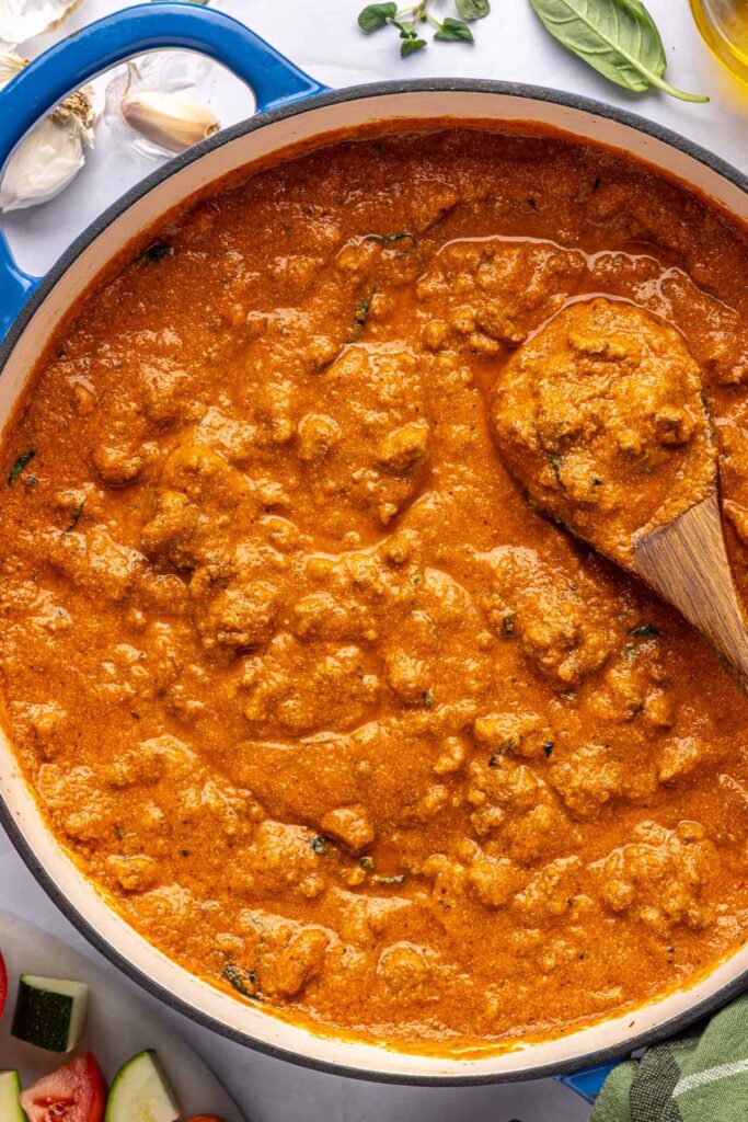 Finished high-protein vodka sauce in a large pot, overhead shot with wooden spoon