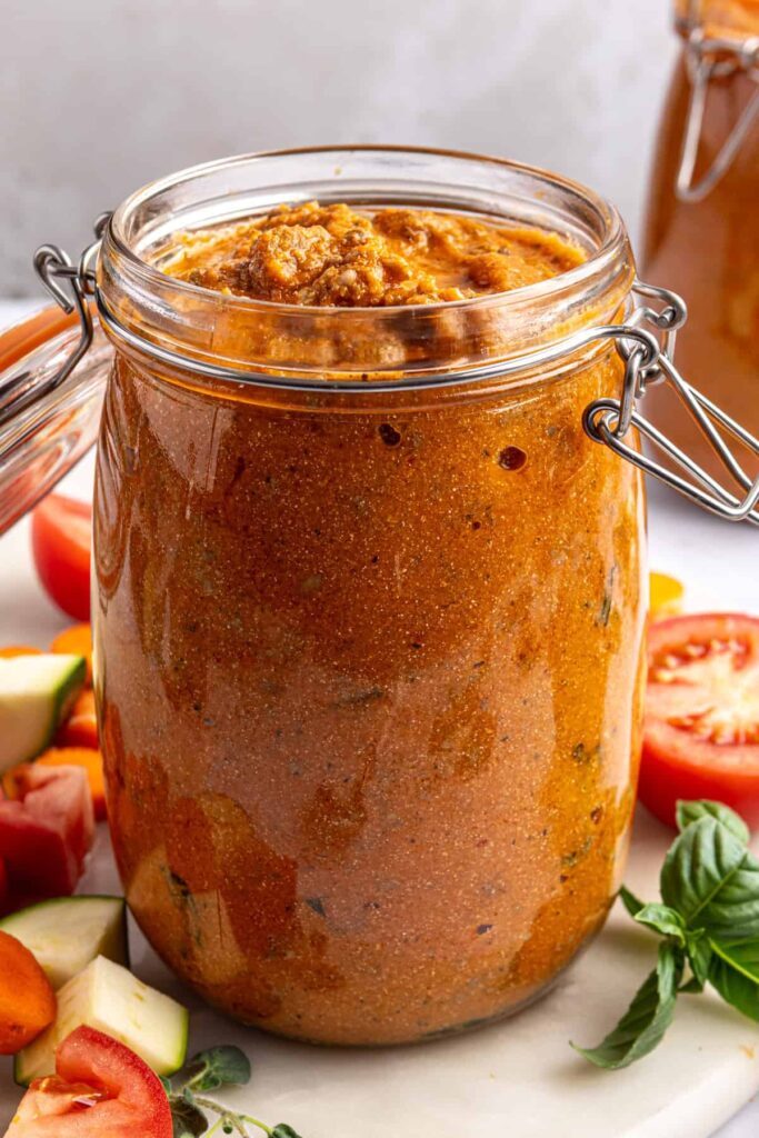 Creamy homemade vodka sauce with hidden veggies stored in a glass jar, styled overhead