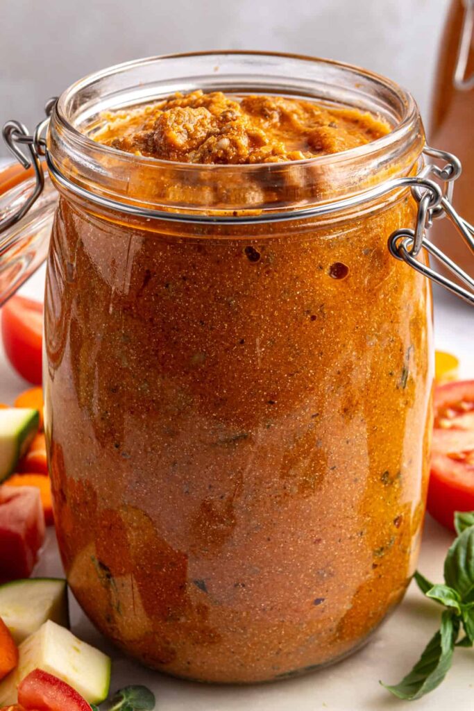 Finished vodka sauce with hidden vegetables in a glass jar, garnished and photographed from above