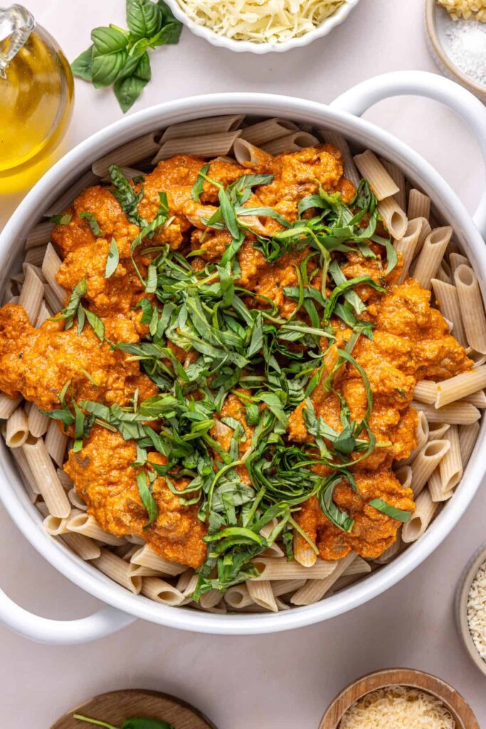 Pasta coated in homemade vodka sauce and fresh basil before assembling easy baked ziti