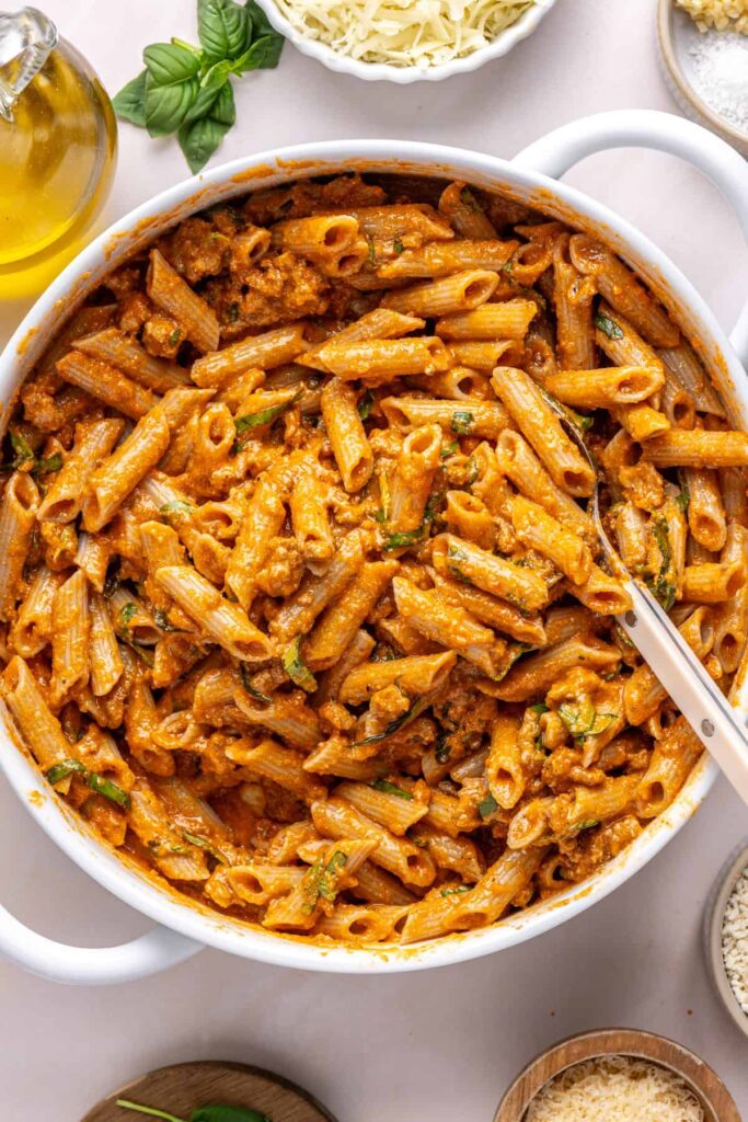 Cooked pasta tossed with creamy vodka sauce and fresh basil for baked ziti