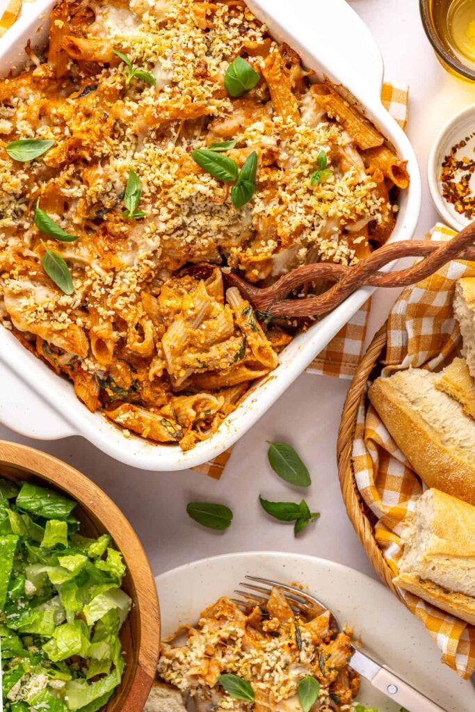 Easy baked ziti in the baking dish with a wooden spoon ready to serve