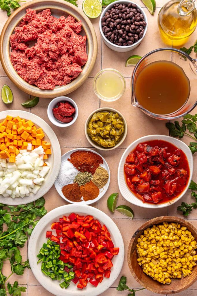 Ingredients for chipotle beef & black bean soup including ground beef, black beans, sweet potato, corn, spices, and bone broth