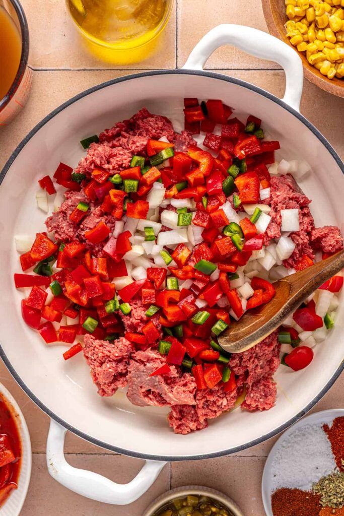 Ground beef browning with onion, bell pepper, and jalapeño in a Dutch oven for chipotle beef & black bean soup