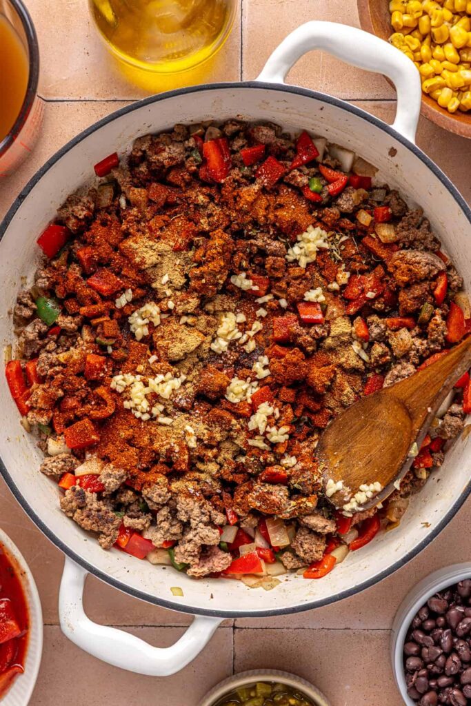 Spices and garlic being toasted with ground beef for chipotle beef & black bean soup