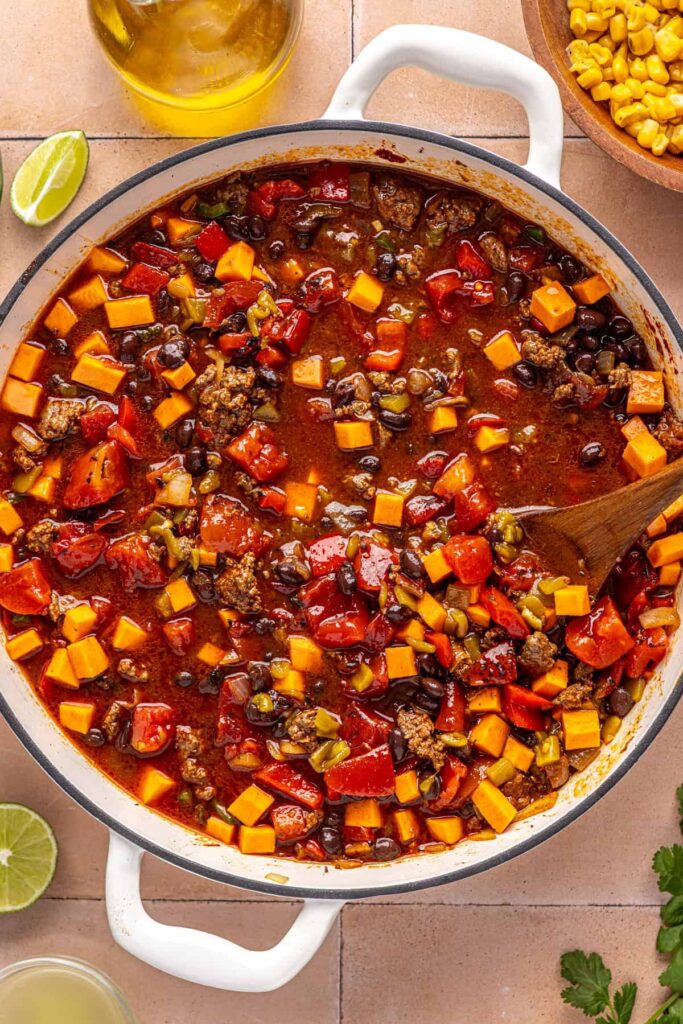Chipotle beef & black bean soup simmering with sweet potatoes in a large pot