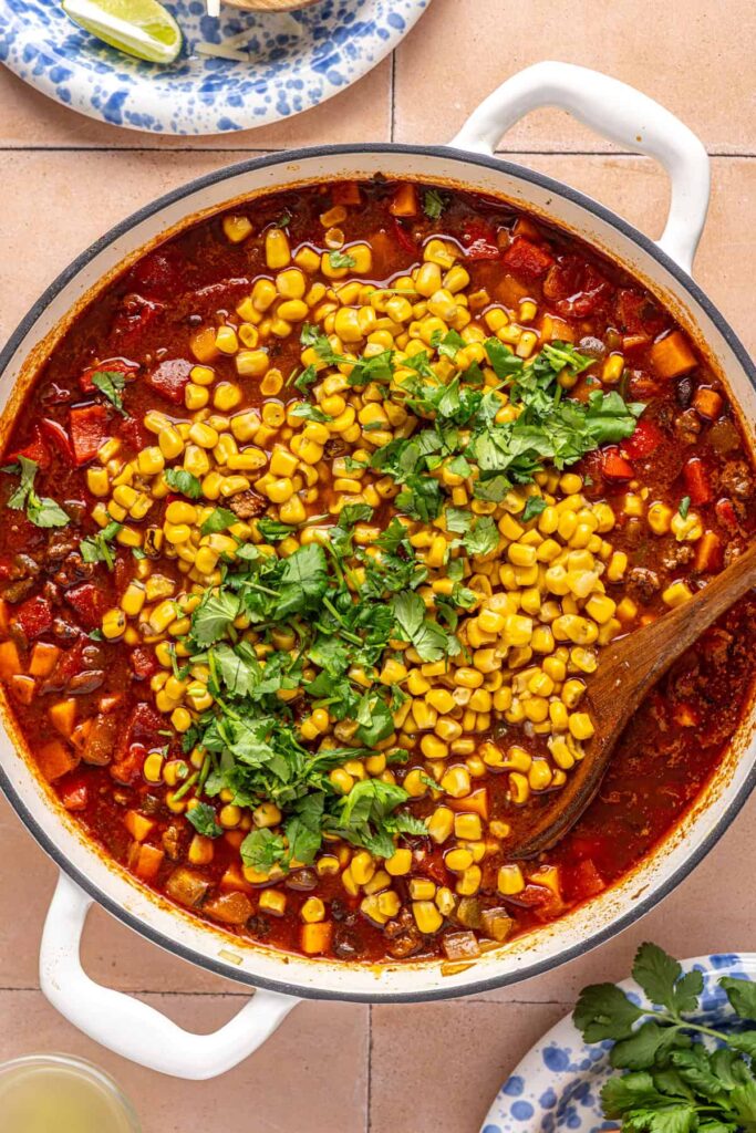 Adding corn and fresh cilantro to chipotle beef & black bean soup