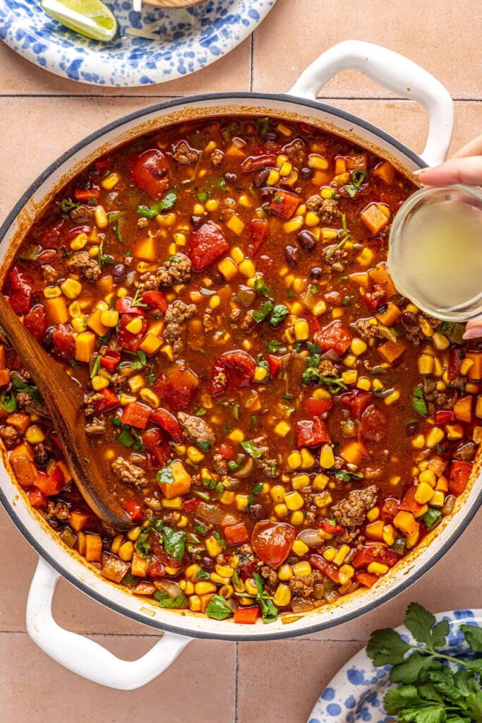 Finishing chipotle beef & black bean soup with lime juice and herbs