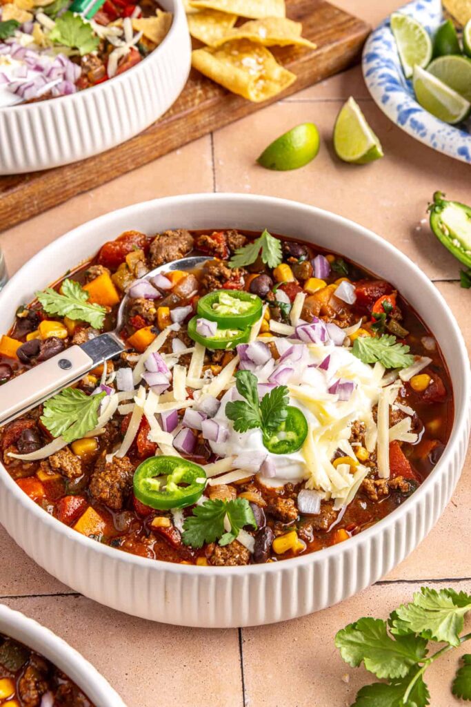 Chipotle beef & black bean soup garnished with cilantro, jalapeños, and crushed tortilla chips