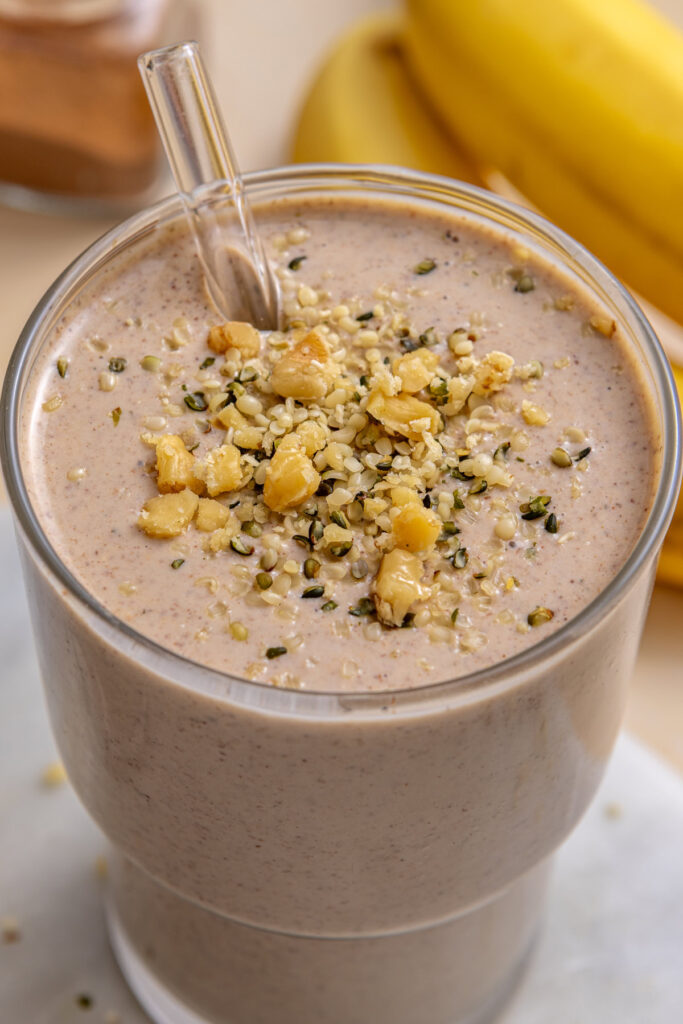 Close-up of thick banana nut smoothie with hemp seeds and crushed nuts on top