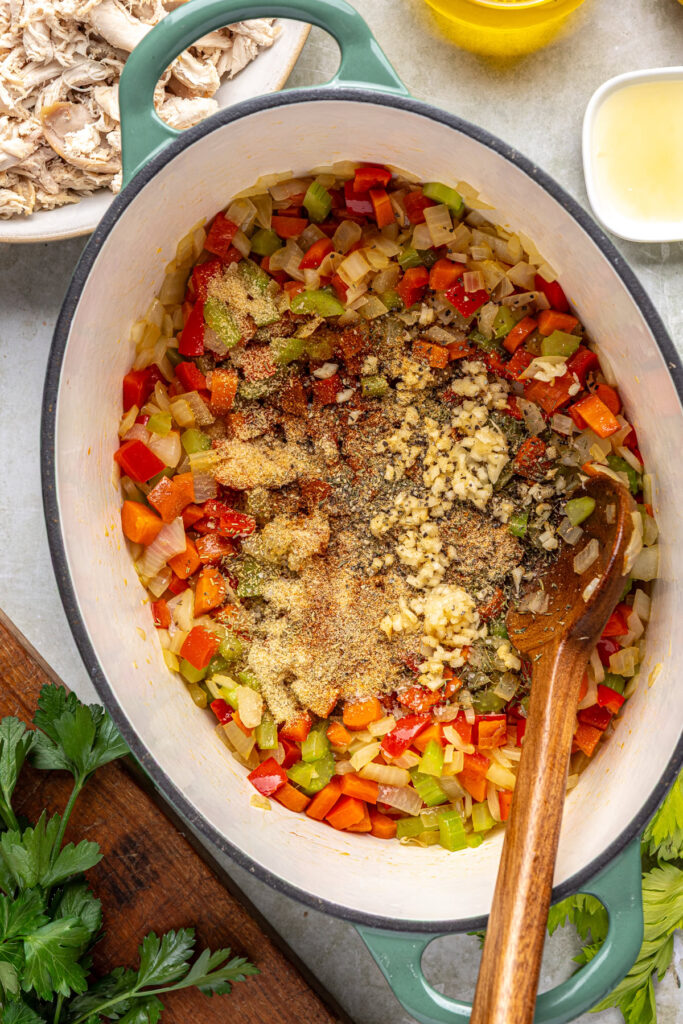 Seasoning vegetables with herbs and spices for cajun chicken soup