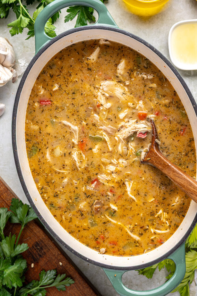 Combining broth mixture with chicken and vegetables for soup