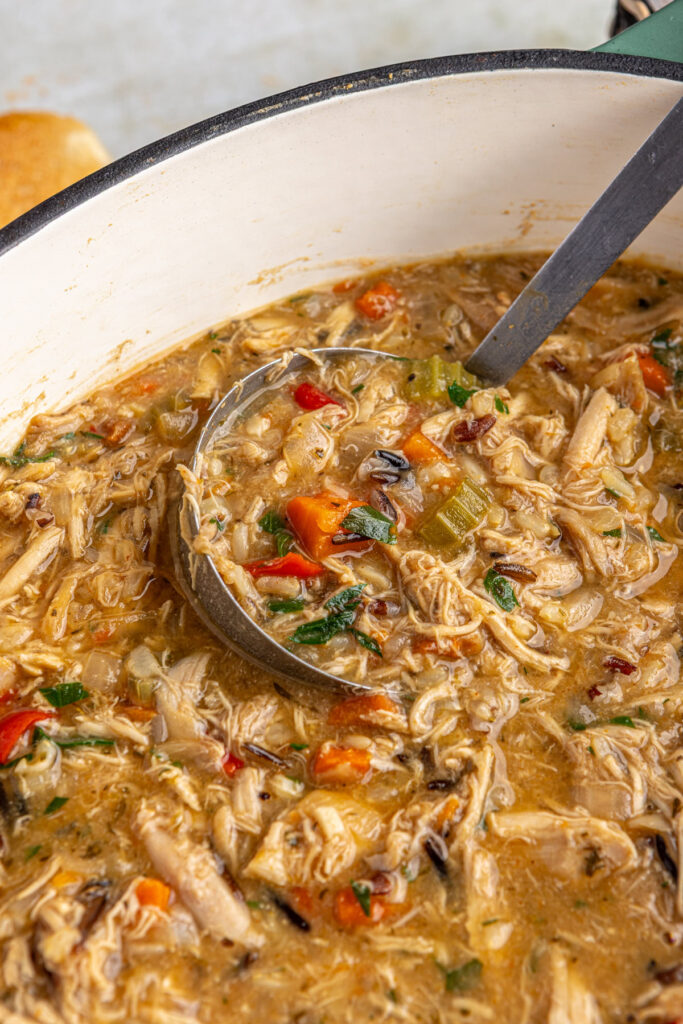 Serving homemade creamy cajun chicken soup with ladle