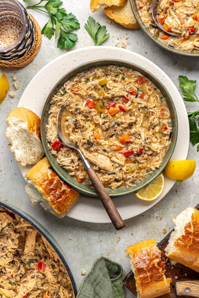 Bowl of creamy cajun chicken soup served with toasted bread and lemon wedges