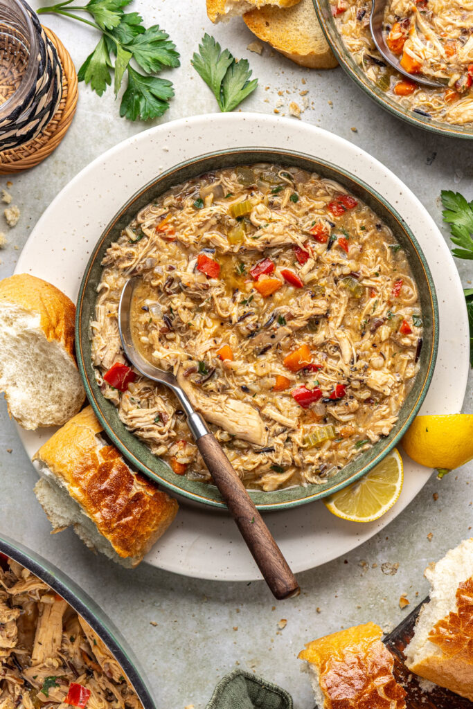 Creamy dairy-free cajun chicken soup plated for dinner with toasted bread and lemon wedges