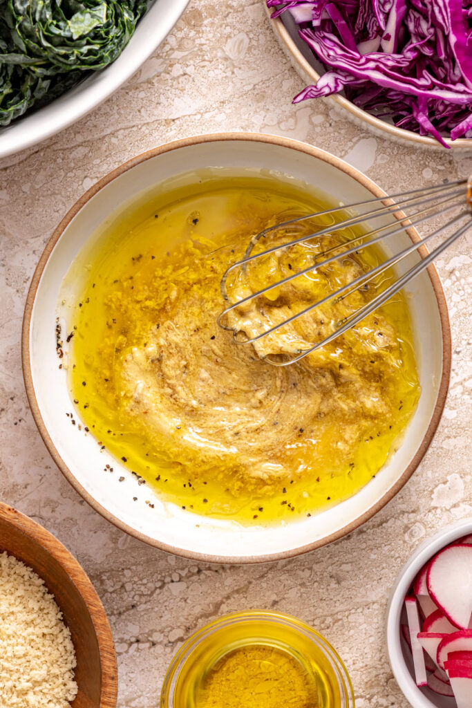Whisking homemade honey mustard dressing in a small bowl