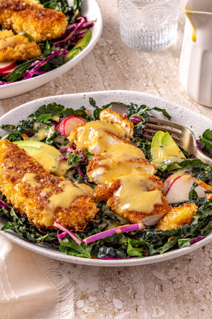side view shot of honey mustard chicken kale salad with fork