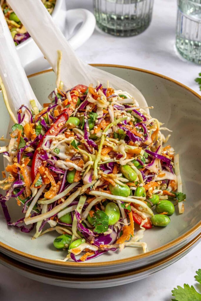 Serving crunchy peanut cabbage salad into individual bowl