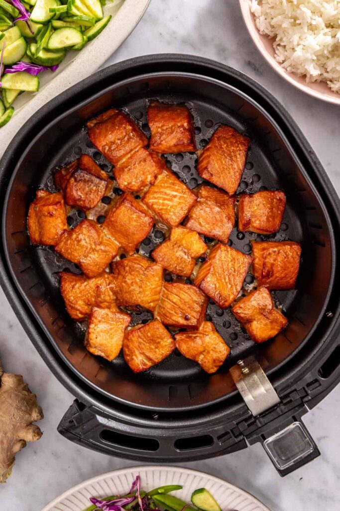 Freshly cooked salmon bites in air fryer basket