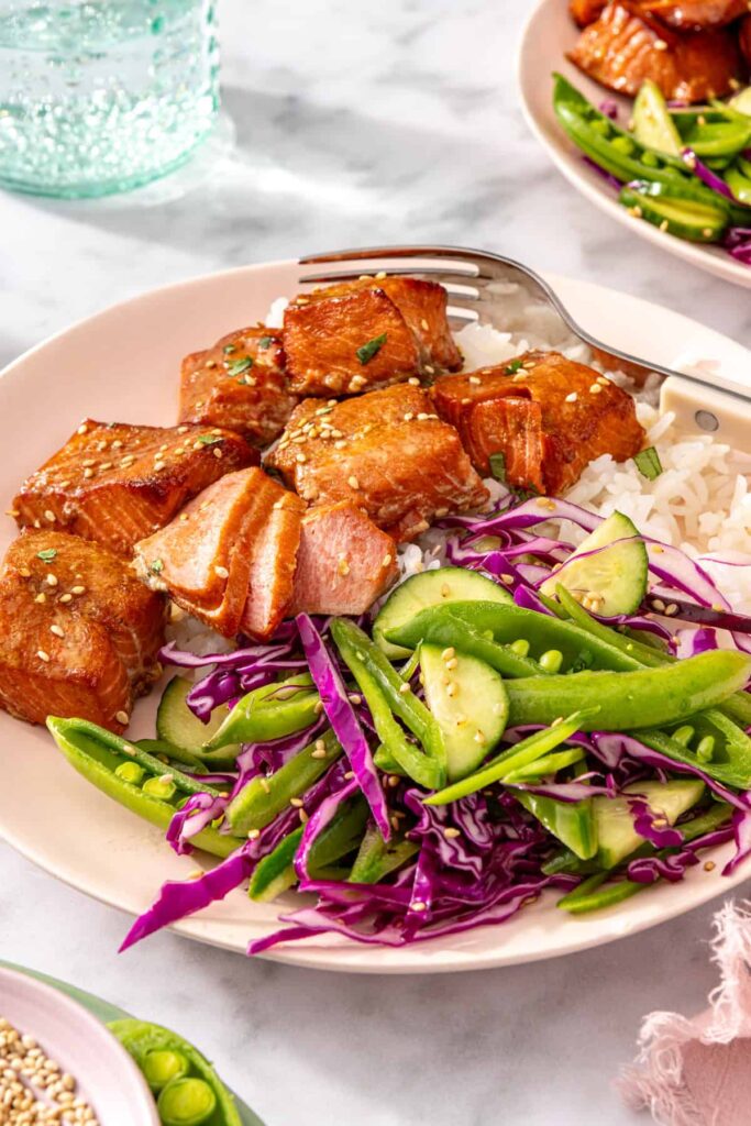 close-up side angle of healthy salmon bites meal with fork and water glasses