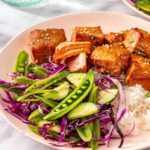 Air fryer salmon bites served with snap pea slaw and rice on a plate
