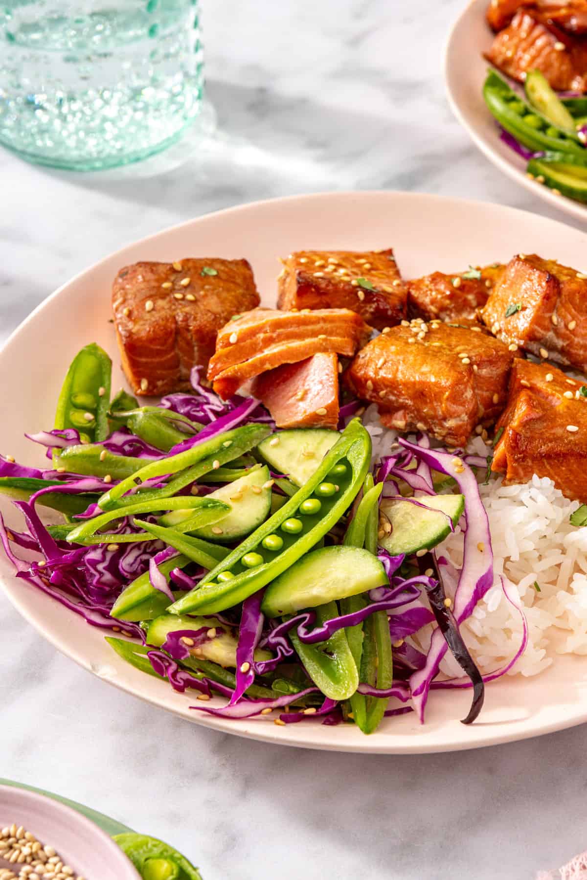 Air fryer salmon bites served with snap pea slaw and rice on a plate