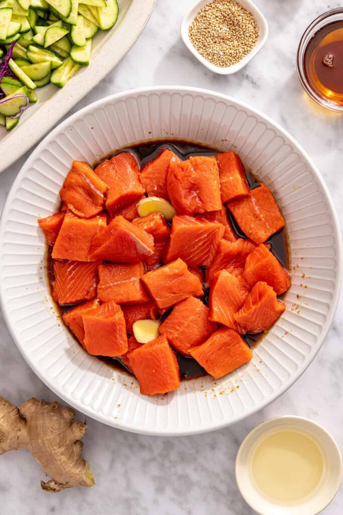 Salmon bites coated in sesame ginger marinade in a bowl