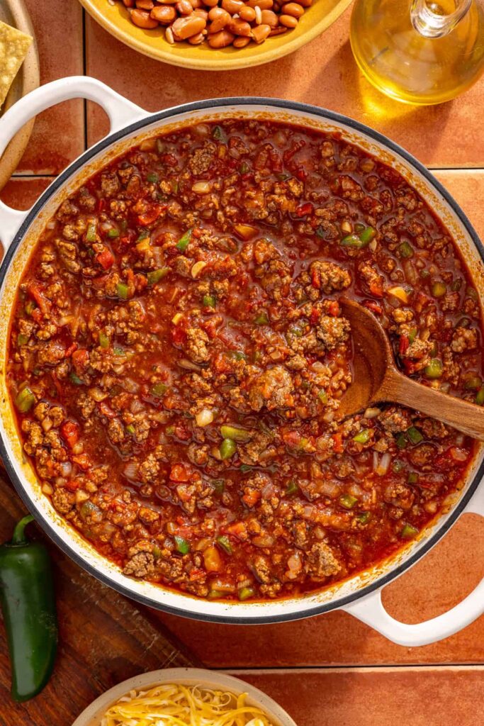 Chili simmering with beans, tomatoes, and broth in skillet