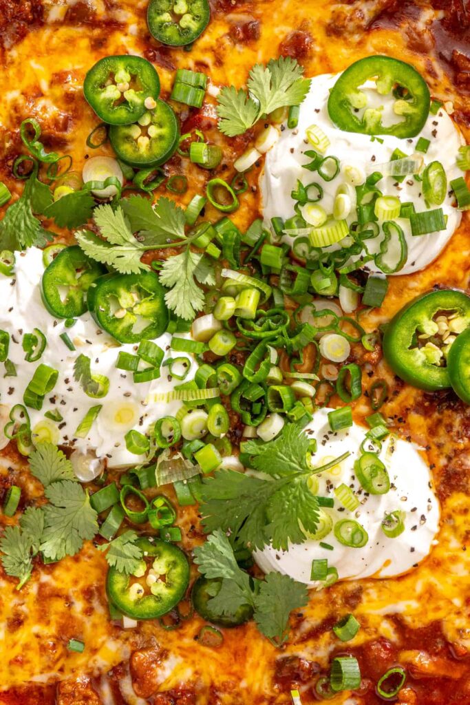 Close-up of cheesy chili skillet with melted cheese and toppings