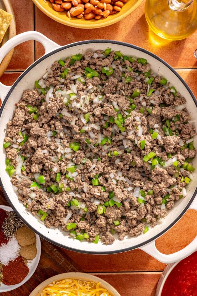 Softening onion and green pepper in skillet for cheesy chili