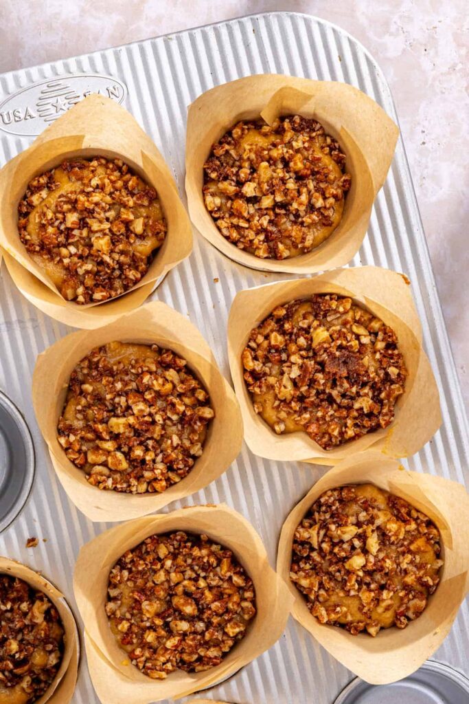 Unbaked coffee cake muffins topped with pecan walnut streusel