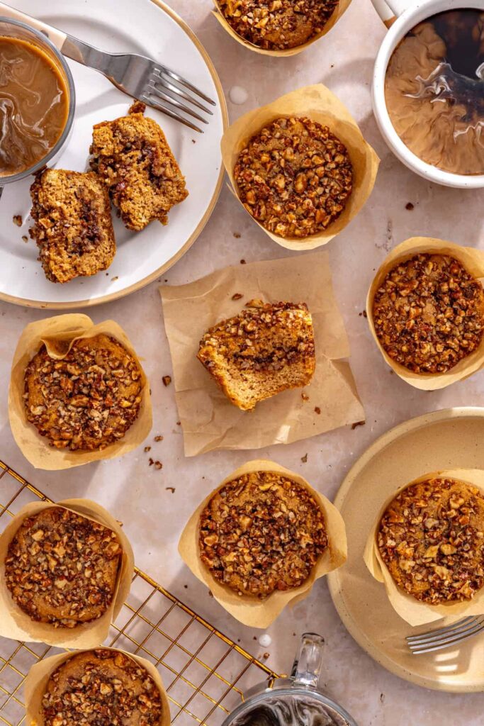 Homemade coffee cake muffins served with coffee on a table with cooling rack