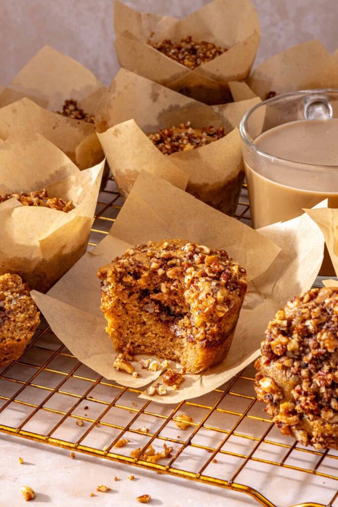 Fresh coffee cake muffin in parchment liner on cooling rack
