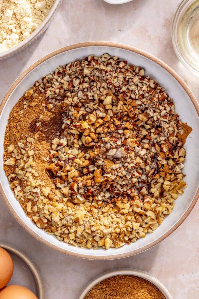 Bowl of cinnamon nut streusel topping being mixed for homemade coffee cake muffins