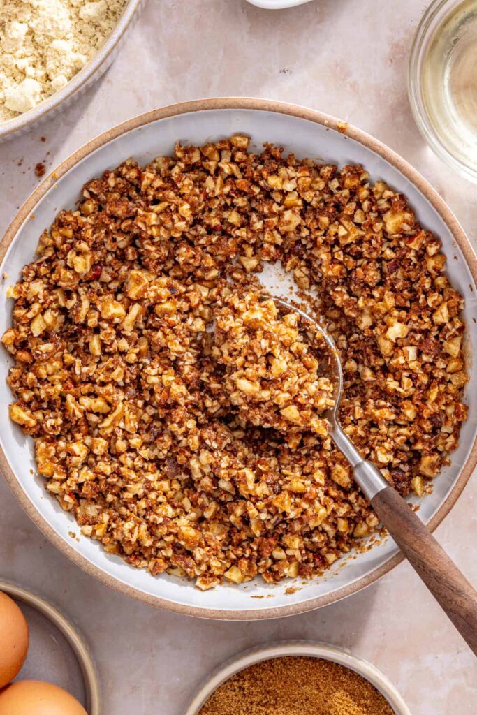 Preparing crunchy streusel topping with pecans and walnuts for coffee cake muffins