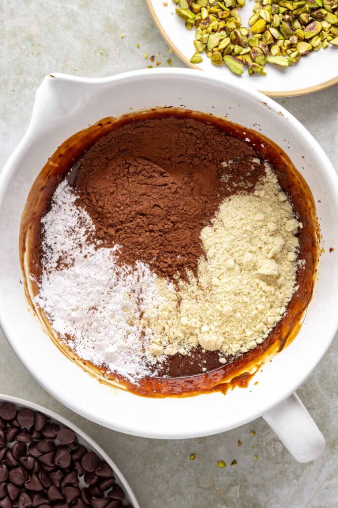 Cocoa powder and almond flour folded into pistachio brownie batter