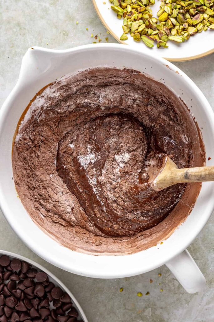 Dry ingredients being folded into chocolate brownie batter